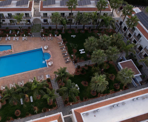 Pool area and trees of Loutsiana Hotel 